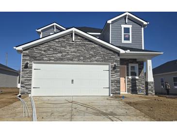 Two-story home with stone accents and a two-car garage at 847 Cypress Preserve Circle, Longs, SC 29568
