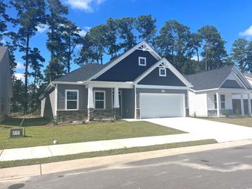 Gray two-story house with white garage door and landscaping at 1057 Nw Rosefield Way, Calabash, NC 28467