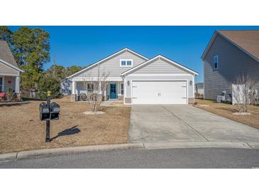 Charming single-story home featuring a two-car garage, blue front door, and well-maintained landscaping at 1141 Bethpage Dr., Myrtle Beach, SC 29579