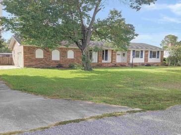 Brick ranch home with a spacious lawn and mature trees at 1203 Sharon Ave., Marion, SC 29571