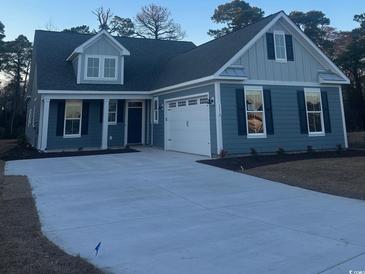 Two-story home featuring gray siding, a two-car garage, and a spacious driveway at 1216 Needle Grass Loop, Myrtle Beach, SC 29579