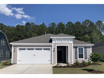 Charming single-story home featuring a two-car garage and manicured front yard with trees in the background at 2155 Gooseberry Way, Longs, SC 29568