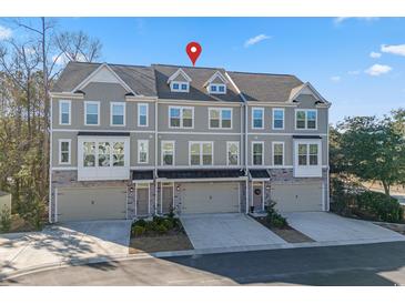 Three-story townhome with gray siding, two-car garage, and landscaping at 2557 Pete Dye Dr. # 1102, North Myrtle Beach, SC 29582