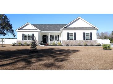 White farmhouse exterior with brick accents and a well-manicured lawn at 262 Ole Maple St., Loris, SC 29569