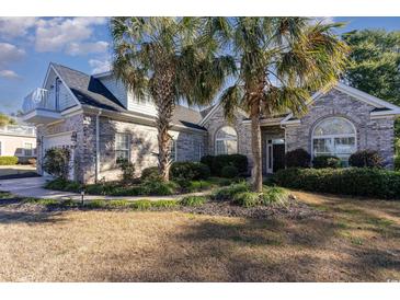 Brick home with palm trees, two-car garage, and balcony at 402 Ocean Pointe Ct., North Myrtle Beach, SC 29582