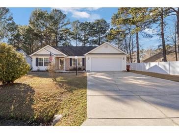 Charming single-story home featuring a well-manicured lawn and a two-car attached garage at 5933 Rahnavard Blvd., Myrtle Beach, SC 29588