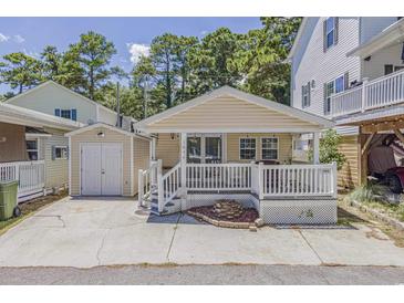 Tan house with white porch and detached garage at 6001-1654 South Kings Hwy., Myrtle Beach, SC 29575