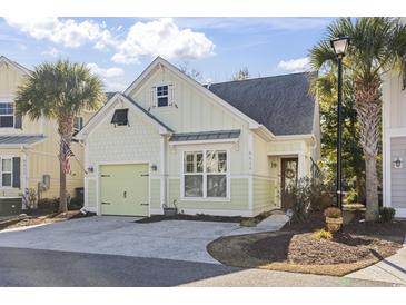 Charming light green house with a two-car garage and landscaping at 6624 Lagoon Pl., Myrtle Beach, SC 29572