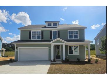Charming two-story home featuring a two-car garage, a light-green exterior, and a well-manicured lawn at 715 Choctaw Dr., Conway, SC 29526