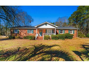 Brick ranch house with a covered porch and a well-manicured lawn at 7152 Highway 134, Conway, SC 29527