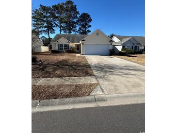 House exterior featuring a two-car garage and a well-maintained lawn at 803 Sultana Dr., Little River, SC 29566