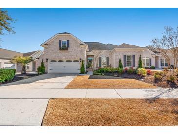 Brick front exterior of charming ranch home with landscaping and two-car garage at 860 Villarosa Dr., Myrtle Beach, SC 29572