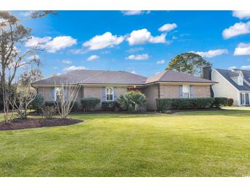 Brick ranch house with landscaped lawn and mature trees at 1671 Arundel Rd., Myrtle Beach, SC 29577