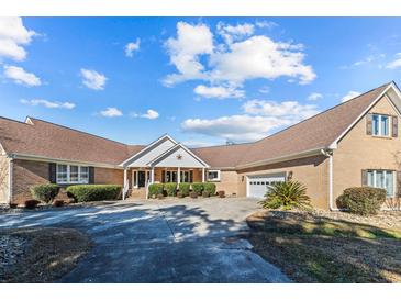 Brick ranch house with a large driveway and landscaped yard at 2409 Royal Oak Circle, North Myrtle Beach, SC 29582