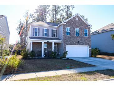 Two-story brick home with a welcoming front porch and attached garage at 2998 Skylar Dr., Myrtle Beach, SC 29577