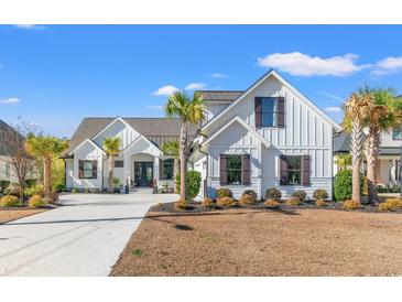 Two-story farmhouse with white siding, dark accents, and palm trees at 5913 Country Club Dr., Myrtle Beach, SC 29577