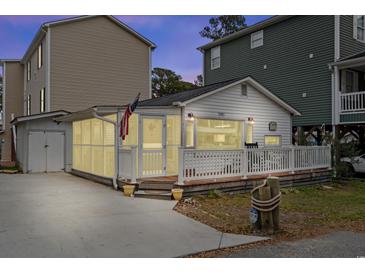 Charming cottage with white exterior, deck, and screened porch at 6001 - 1861 S Kings Hwy., Myrtle Beach, SC 29575