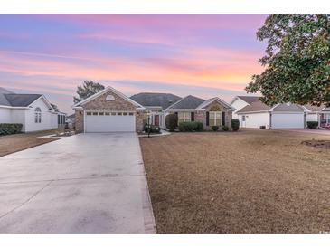 Brick ranch home with attached garage and landscaped lawn at 6925 Ashley Cove Dr., Myrtle Beach, SC 29588