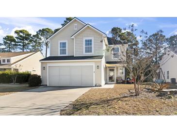 Two-story house with light beige siding, a large garage, and a landscaped front yard at 817 Old Castle Loop, Myrtle Beach, SC 29579