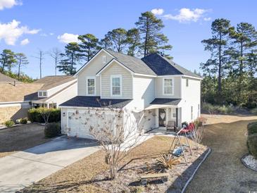 Charming two-story home with attached garage, landscaped yard, and inviting front porch on a sunny day at 817 Old Castle Loop, Myrtle Beach, SC 29579