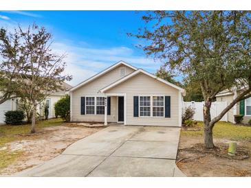 Tan house with dark brown trim, driveway, and landscaping at 869 Silvercrest Dr., Myrtle Beach, SC 29579