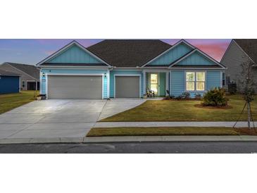 Charming light blue house with gray garage and landscaped lawn at 1410 Saw Palmetto St., North Myrtle Beach, SC 29582