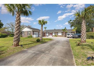 Brick ranch house with palm trees, long driveway, and attached garage at 1530 Deer Park Ln., Surfside Beach, SC 29575