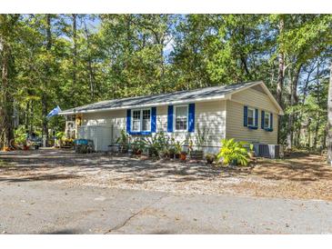 Charming single story home with blue accents and landscaped yard at 2102 Calabash Circle, Little River, SC 29566