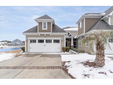 Snow covered exterior of charming townhome with attached garage and landscaping at 6244 Catalina Dr. # 1411, North Myrtle Beach, SC 29582