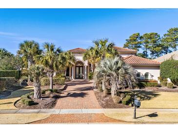 Grand two-story home with brick driveway, lush landscaping, and palm trees at 9237 Bellasara Circle, Myrtle Beach, SC 29579