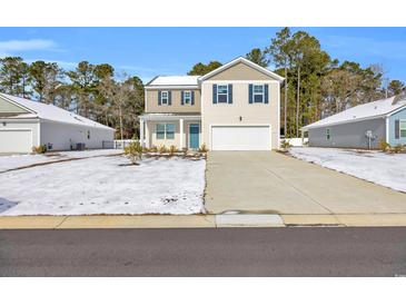 Two-story house with light beige vinyl siding, a white garage door, and a teal front door at 274 Columbus St., Conway, SC 29526