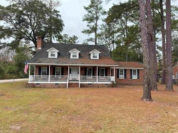 Charming brick home featuring a welcoming front porch, dormer windows and a beautiful lawn at 305 W Raft St., Nichols, SC 29581