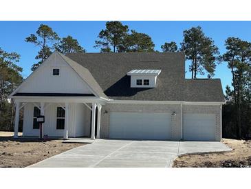 Charming one-story home featuring white siding and a three-car garage at 45 Northbrook Dr, Murrells Inlet, SC 29576