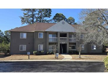 Two-story condo building with brown siding, balconies, and landscaping at 500 Myrtle Greens Dr. # A, Conway, SC 29526