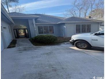 Gray house with attached garage and walkway at 1818 Topsail Ln., North Myrtle Beach, SC 29582
