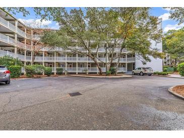 Condominium complex featuring multiple levels, ample parking, and mature shade trees at 415 Ocean Creek Dr. # 2139, Myrtle Beach, SC 29572