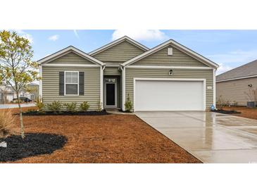 Charming single-story home with a two-car garage, manicured lawn, and neutral green siding at 775 Oyster Bluff Dr., Myrtle Beach, SC 29588