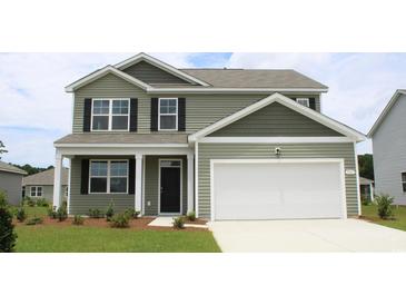 Two-story house with green siding, white garage door, and landscaping at 8059 Bear Claw Way, Conway, SC 29526