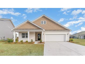 Two-story house with a light brown exterior, white garage door, and landscaping at 1118 Barrington Way, Conway, SC 29526