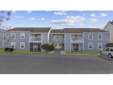 Front view of a two-story building with several units, featuring a gray exterior and balconies at 1356 Glenns Bay Rd. # E 204, Surfside Beach, SC 29575