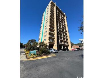 Ocean Dunes Tower II condo building, featuring a multi-story structure with balconies and ample parking at 7500 N Ocean Blvd. # 6145, Myrtle Beach, SC 29572
