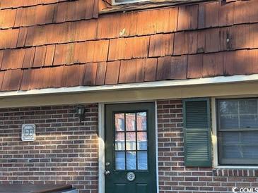 Brick building exterior with a dark green door and wood shake roof at 1025 Carolina Rd. # Ee-3, Conway, SC 29526