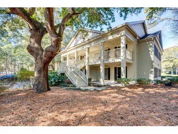 Charming home featuring a double porch and exterior stairway, shaded by a mature tree at 14 Stillwood Dr. # 2, Pawleys Island, SC 29585
