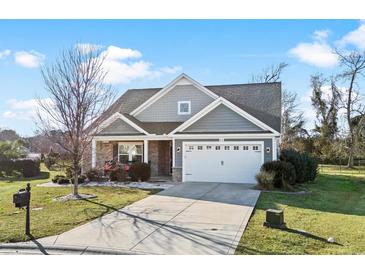 Gray house with stone accents, white garage door, and landscaping at 417 San Benito Ct., Longs, SC 29568