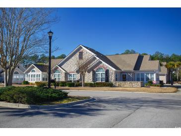 Stone-clad home featuring arched windows, shutters, and a well-manicured landscape at 160 Stonegate Blvd. # 160, Murrells Inlet, SC 29576