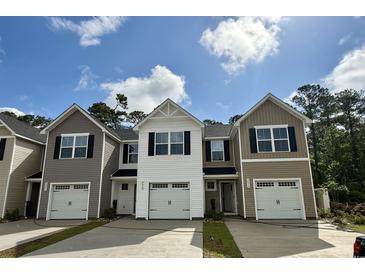 New townhomes displaying varied siding, black shutters, one-car garages, and concrete driveways at 265 Christiana Ln. # A, Myrtle Beach, SC 29579