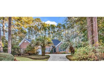 Charming brick home with well-manicured landscaping and a private driveway at 385 Muirfield Dr., Pawleys Island, SC 29585