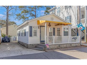 Charming cottage with yellow awning, white siding, and stone accents at 6001-Z34 S Kings Hwy., Myrtle Beach, SC 29575