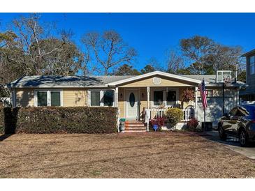 Charming ranch home with well-manicured lawn and American flag at 706 33Rd Ave. S, North Myrtle Beach, SC 29582