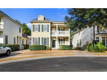 Two-story house with light beige siding, dark shutters, and a front porch at 171 Beaufain Ct., Pawleys Island, SC 29585